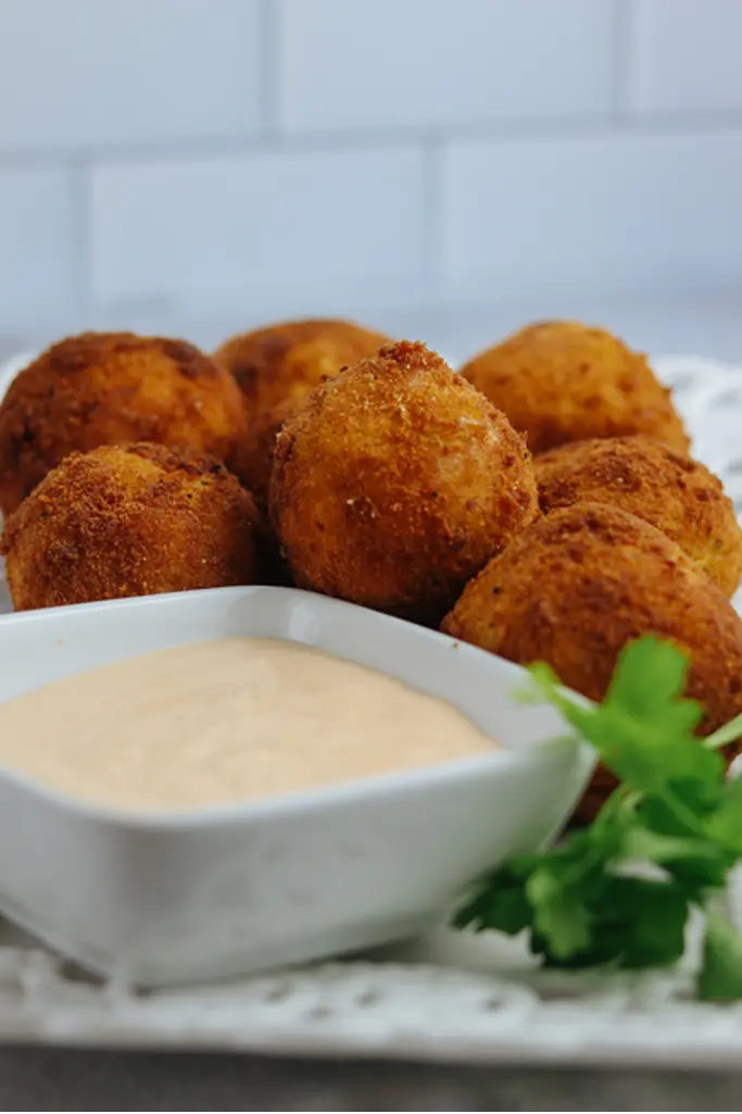 Golden crispy stuffed plantain balls with spiced cod fish filling served warm on a plate