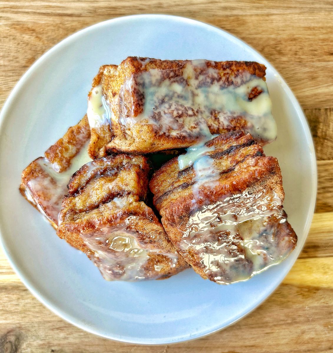Nutella stuffed brioche French toast stacked on a plate drizzled with sweetened condensed milk
