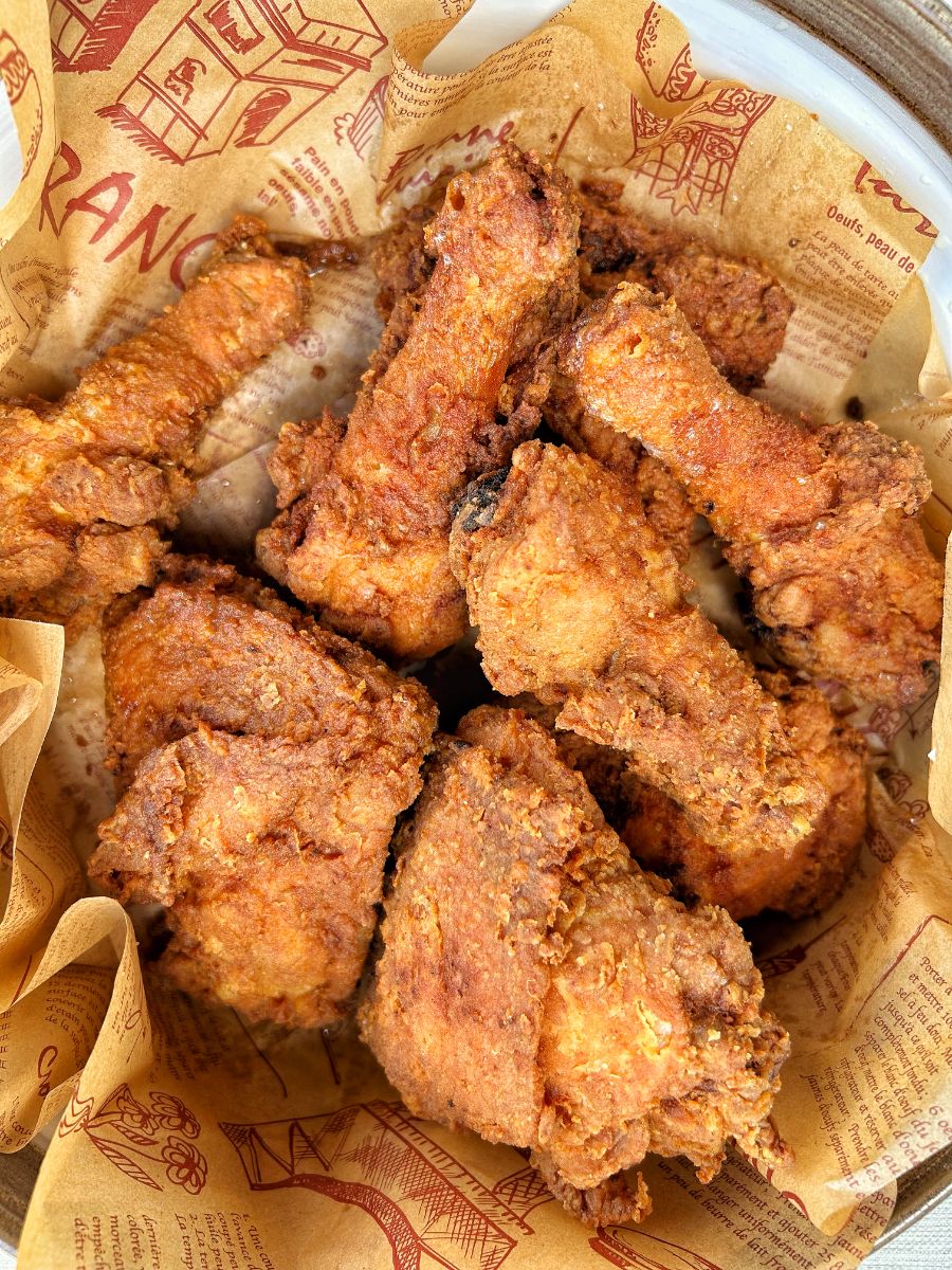 Crispy Caribbean fried chicken with golden crunchy coating served with quinoa and steamed vegetables on a plate